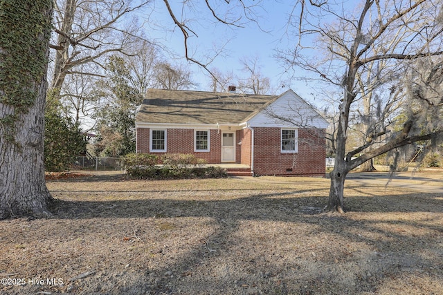 bungalow-style home with brick siding, crawl space, and fence