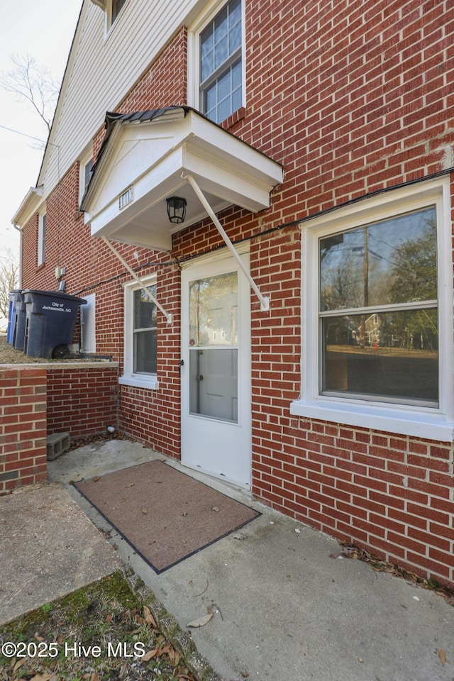 entrance to property featuring brick siding