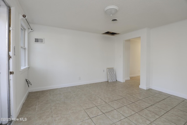 spare room with visible vents, baseboards, and light tile patterned floors