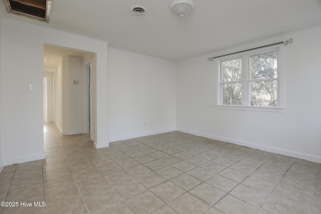 empty room featuring light tile patterned floors, visible vents, and baseboards