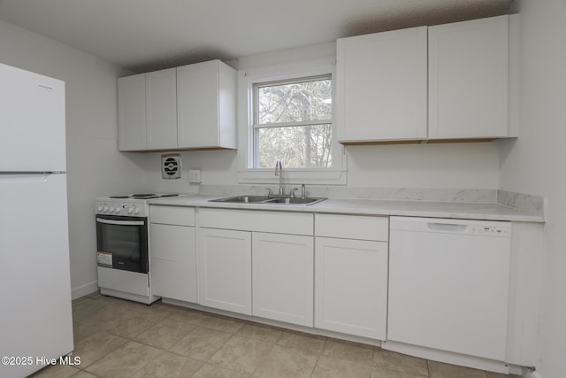 kitchen with light tile patterned floors, white appliances, a sink, white cabinetry, and light countertops