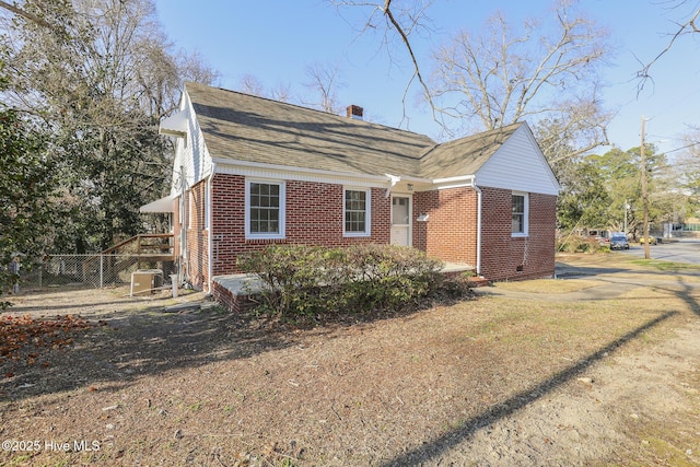 view of property exterior with brick siding, a chimney, a shingled roof, crawl space, and fence