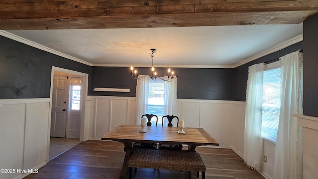 dining room featuring crown molding, wainscoting, wood finished floors, and an inviting chandelier