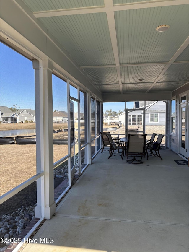 sunroom featuring a water view