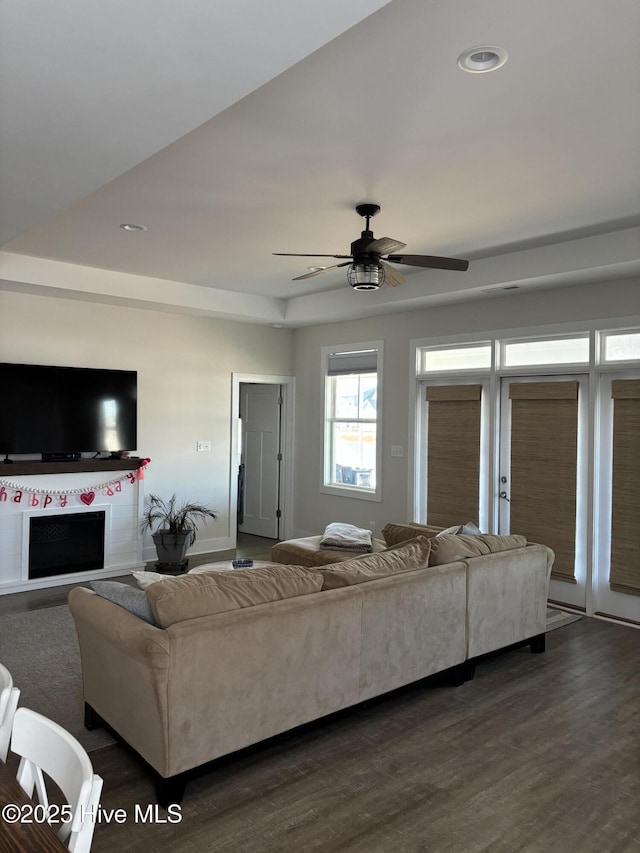 living area with recessed lighting, a fireplace, ceiling fan, and dark wood-style flooring