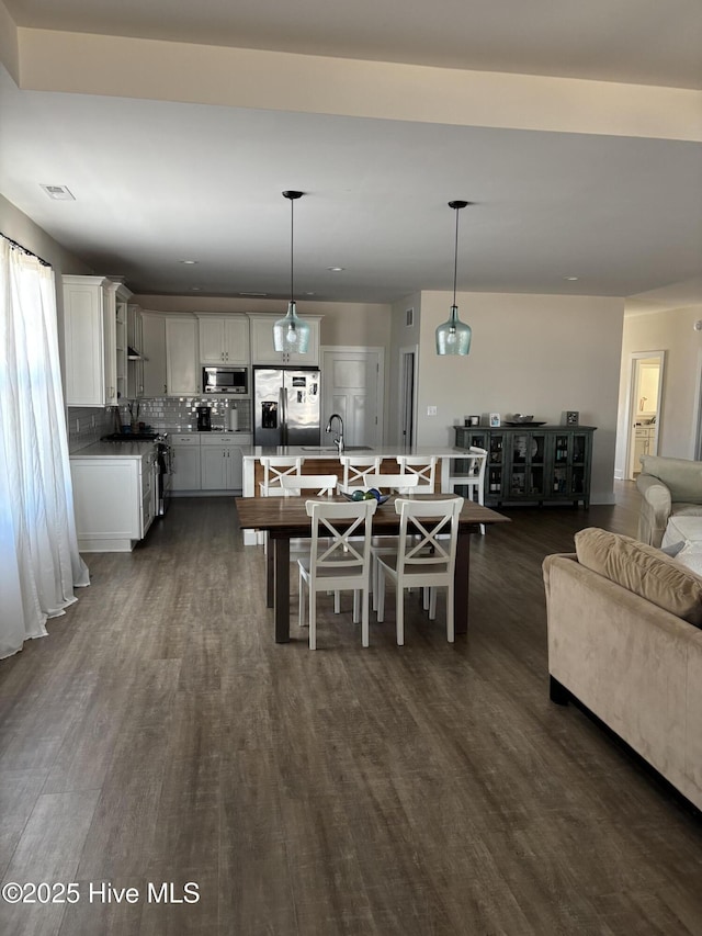 dining area featuring dark wood-style flooring and visible vents