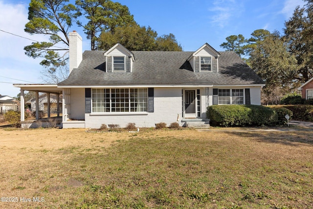 cape cod house featuring a shingled roof, a chimney, a front lawn, a carport, and brick siding