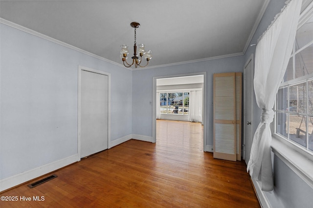 dining area with baseboards, visible vents, ornamental molding, wood finished floors, and an inviting chandelier