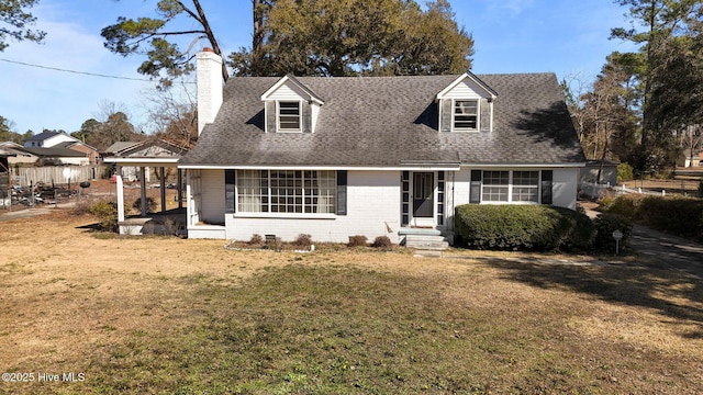 cape cod-style house with a chimney, roof with shingles, fence, a front yard, and brick siding