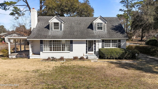 cape cod-style house with a front lawn, a chimney, a shingled roof, and brick siding