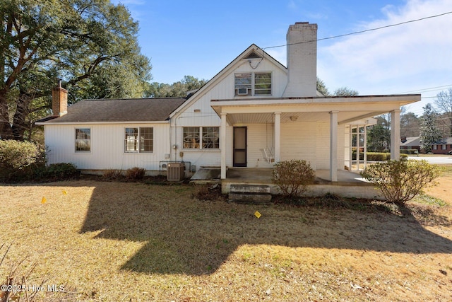 view of front of home with a chimney and cooling unit