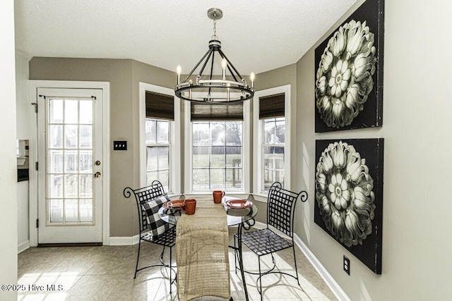 tiled dining area with baseboards, an inviting chandelier, and a healthy amount of sunlight