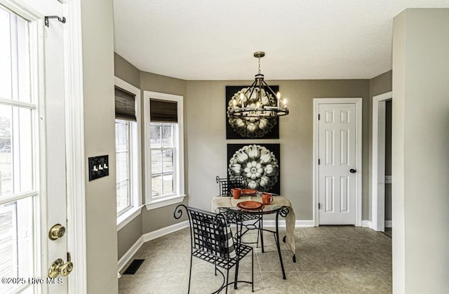 tiled dining room featuring baseboards, visible vents, and a notable chandelier