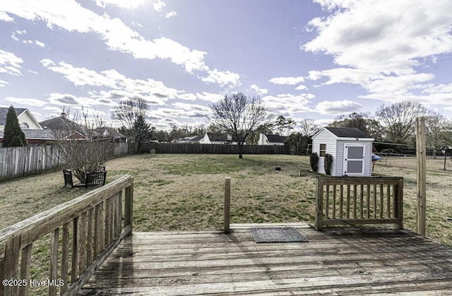 deck featuring an outbuilding, a fenced backyard, a yard, and a shed