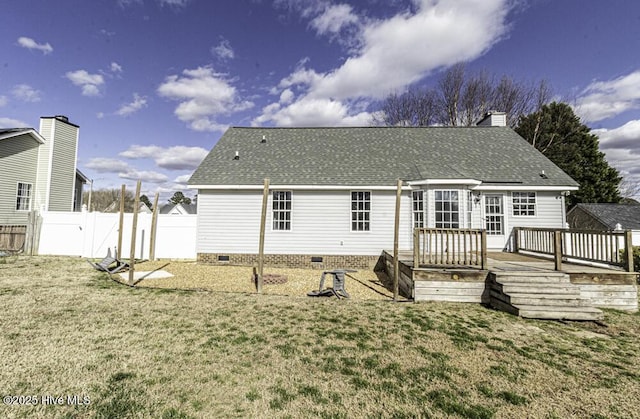 rear view of house featuring a chimney, a lawn, crawl space, fence, and a wooden deck