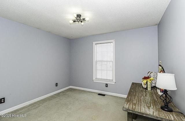 interior space with carpet floors, baseboards, visible vents, and a textured ceiling