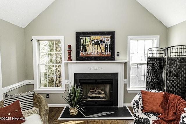 living room with vaulted ceiling, a fireplace, and plenty of natural light