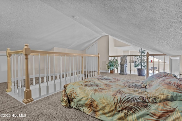 carpeted bedroom with vaulted ceiling and a textured ceiling