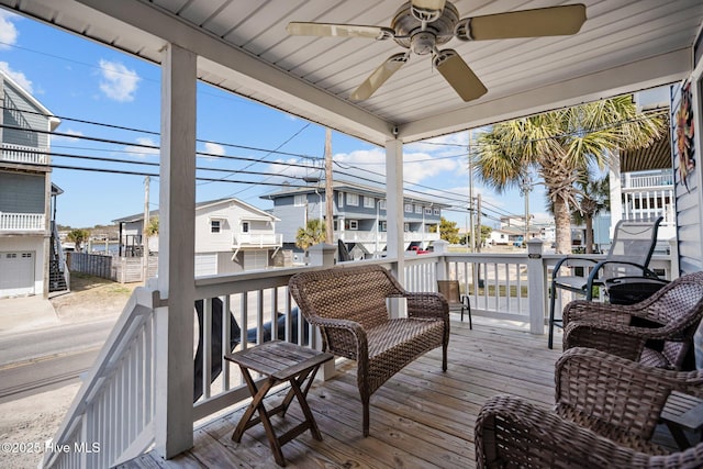 wooden terrace with a residential view and a ceiling fan