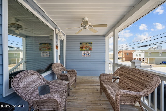 sunroom / solarium featuring a ceiling fan and a residential view