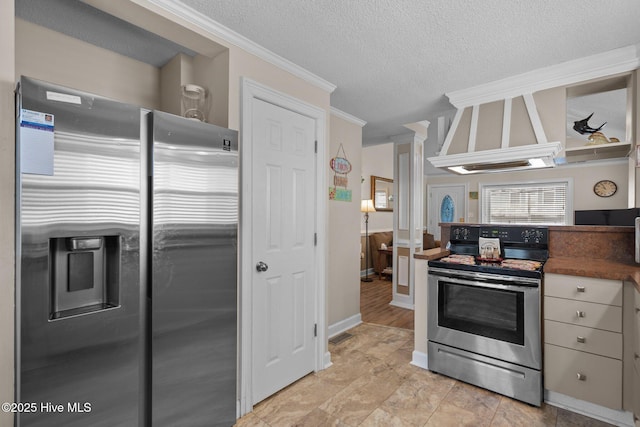 kitchen featuring premium range hood, ornate columns, ornamental molding, appliances with stainless steel finishes, and a textured ceiling