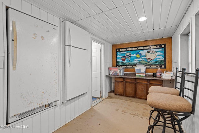 interior space with unfinished concrete floors and wood ceiling