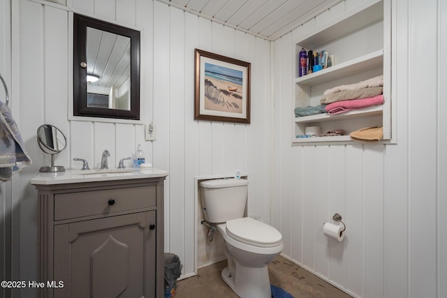 half bath featuring built in features, toilet, and vanity