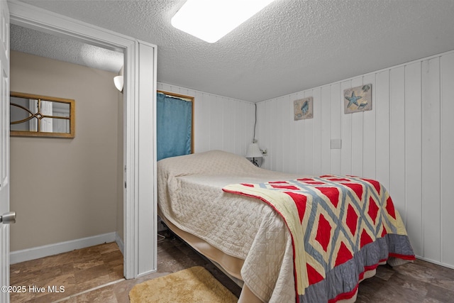 bedroom featuring baseboards and a textured ceiling