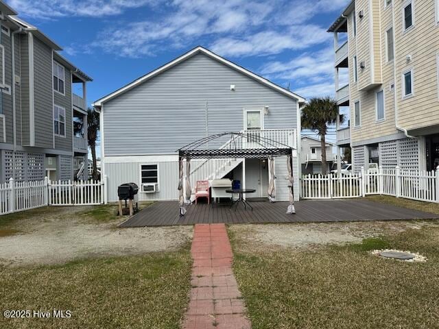 rear view of property with a deck and fence