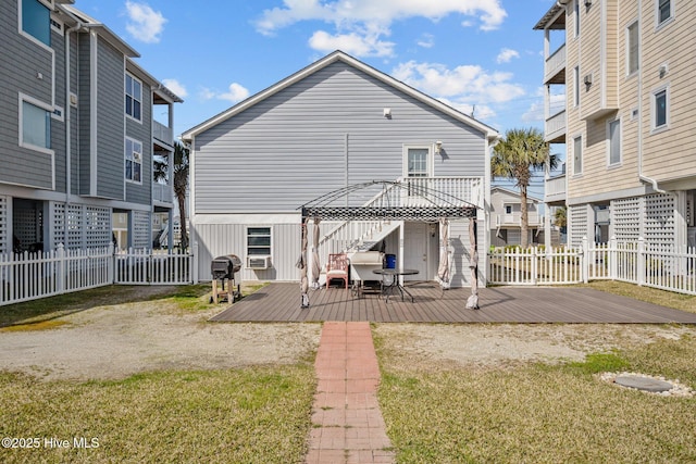 back of house with a residential view, a deck, and fence