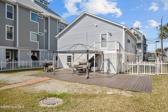 back of house with a gazebo, a wooden deck, and fence