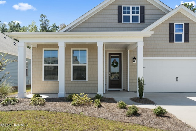 view of front of home featuring concrete driveway, covered porch, and an attached garage