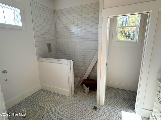 full bathroom with baseboards, plenty of natural light, tile patterned flooring, and a walk in shower