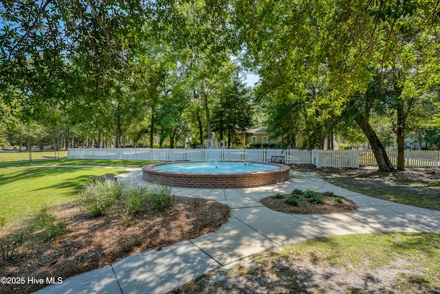 view of community with fence and a lawn