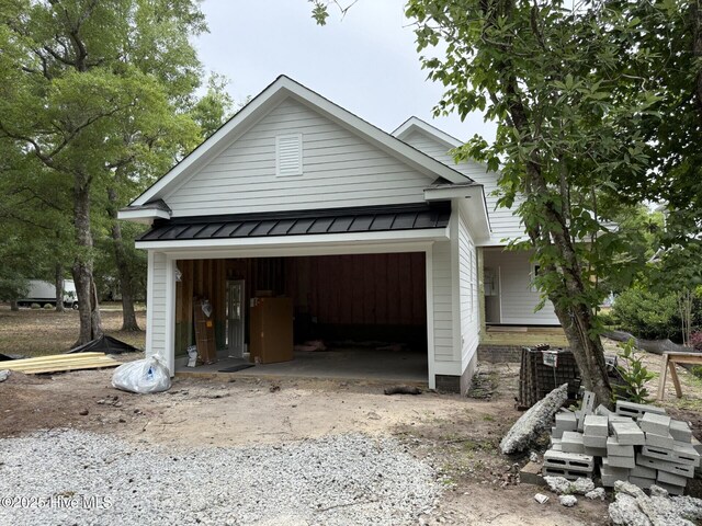 9118 E Lake Rd, Calabash, NC 28467 - view of front facade featuring a standing seam roof, metal roof, and an attached garage