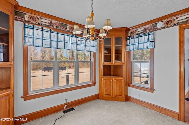 dining space with a chandelier, visible vents, a textured ceiling, and baseboards