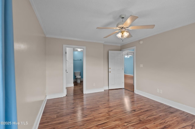 spare room featuring a textured ceiling, wood finished floors, a ceiling fan, baseboards, and crown molding