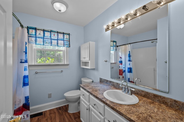 full bathroom with visible vents, toilet, vanity, wood finished floors, and baseboards