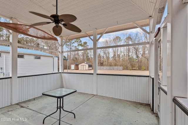 exterior space featuring a ceiling fan, an outdoor structure, and a storage shed