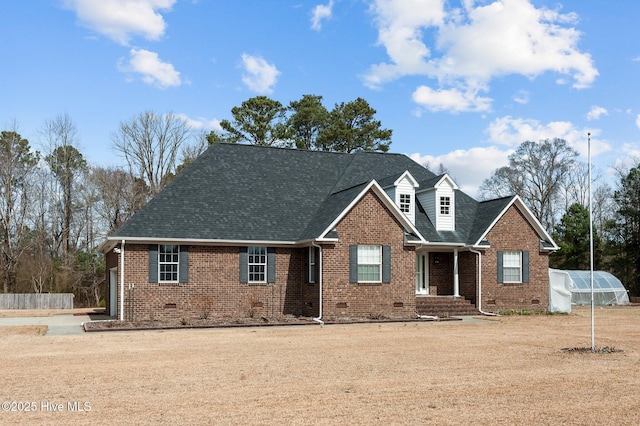 view of front of home featuring an outbuilding, brick siding, roof with shingles, an exterior structure, and crawl space