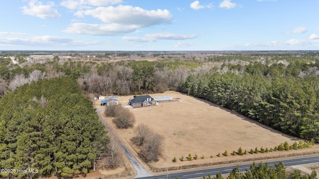 birds eye view of property featuring a rural view and a wooded view