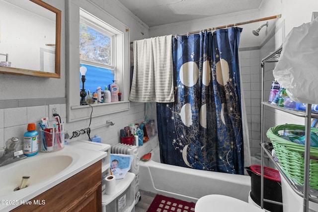 full bathroom featuring toilet, tile walls, vanity, ornamental molding, and shower / tub combo with curtain