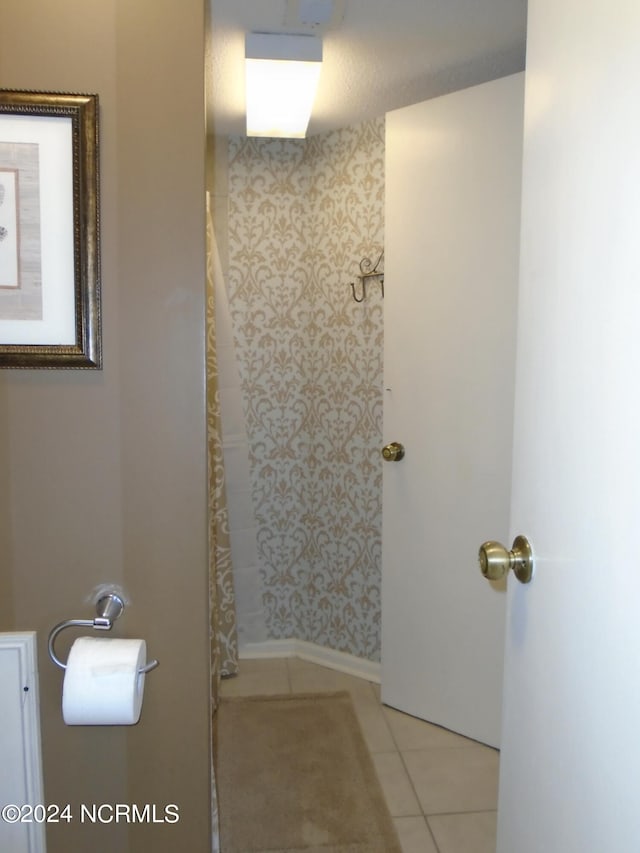 full bath with curtained shower and tile patterned floors