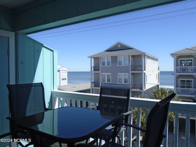 balcony featuring a water view and outdoor dining area