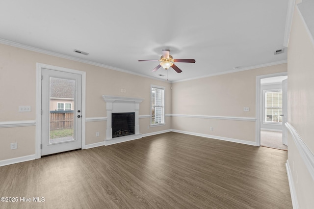 unfurnished living room with plenty of natural light, dark wood finished floors, visible vents, and a fireplace with raised hearth