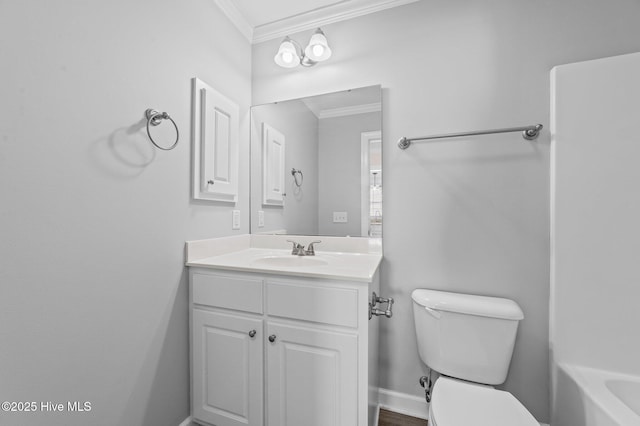 bathroom featuring baseboards, toilet, a bathing tub, ornamental molding, and vanity