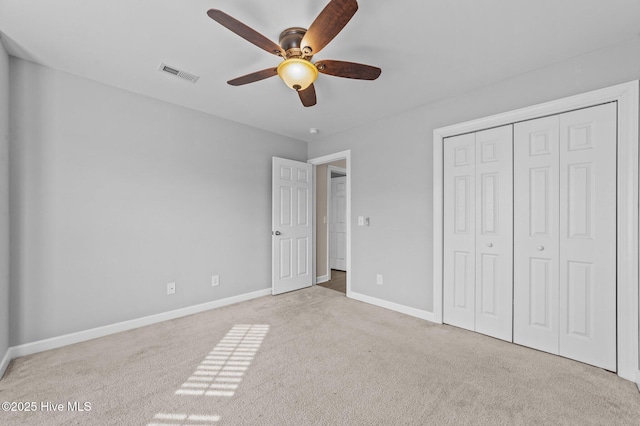 unfurnished bedroom featuring carpet, a closet, visible vents, and baseboards