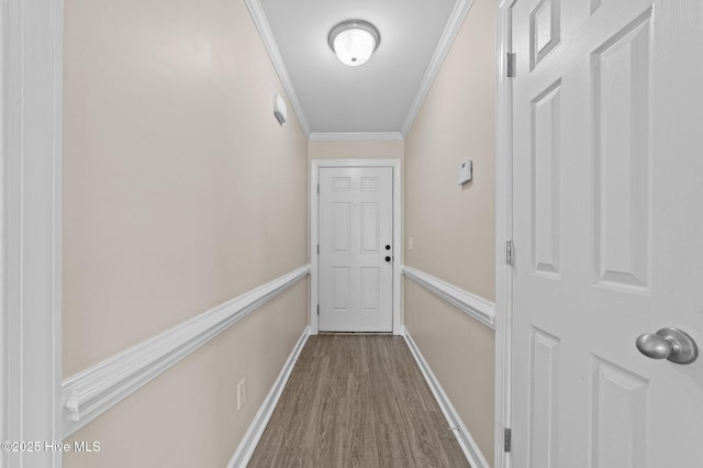 doorway with crown molding, baseboards, and wood finished floors