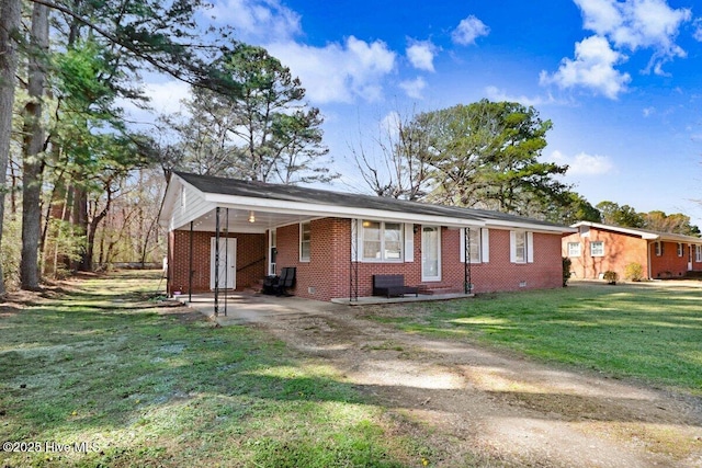 view of front of home featuring an attached carport, a front yard, dirt driveway, crawl space, and brick siding