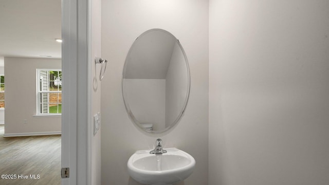 bathroom with a sink, baseboards, and wood finished floors